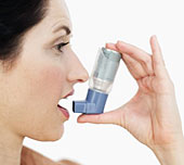 Man sieht eine Frau, die einen Inhalator benutzt.