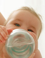 Ein S�ugling trinkt Wasser aus einer Flasche.