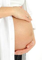 Schwangere Frau umfasst ihren Bauch