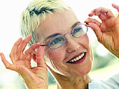 Blonde Frau setzt sich Brille auf