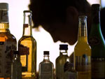 Das Bild zeigt einen Jugendlichen mit Alkoholflaschen. 