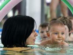 Das Bild zeigt eine Mutter mit ihrem Kind beim Schwimmen.