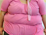 Der Bauch einer �bergewichten Frau mit einem rosafarbenen T-Shirt.