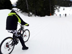 Das Bild zeigt einen Mountainbikefahrer im Schnee.