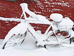 Man sieht ein schneebedecktes Fahrrad.
