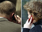 Man sieht einen Mann und eine Frau von hinten, beide telefonieren mit einem Handy.