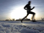 Das Bild zeigt einen Jogger im Schnee.