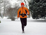 Das Bild zeigt einen Jogger im Schnee.