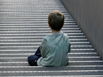 Das Bild zeigt ein zur�ckgezogenes Kind auf einer Treppe.