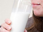 Eine Frau hält ein Glas Milch in der Hand.
