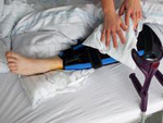 Ein Patient mit einer Beinverletzung wird gepflegt.