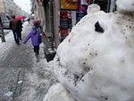 Ein Schneemann steht auf einem verschneiten Gehweg. 