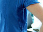 Das Bild zeigt eine Person in einem verschwitzten T-Shirt.