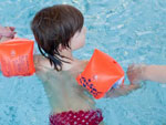 Das Bild zeigt ein Kind mit Schwimmfl�geln im Wasser.