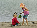 Zwei Kinder spielen am Strand.