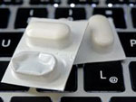 Man sieht eine Tablettenschachtel, die auf einer Tastatur liegt. 