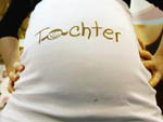 Ein Babybauch, dessen T-Shirt den Aufdruck 