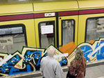 Man sieht eine U-Bahn und einen Bahnsteig mit Menschen.