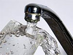 Aus einem Wasserhahn flie�t Wasser in ein Glas.