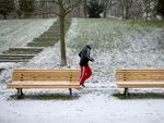 Das Bild zeigt einen Mann, der durch den Schnee joggt. 
