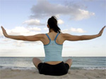 Eine Frau macht am Strand eine Yogaübung
