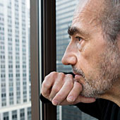 Ein �lterer Mann blickt nachdenklich aus dem Fenster.