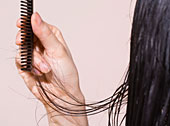 Dunkelhaarige Frau k�mmt sich die nassen Haare.