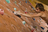 Ein Mann der an einer Kletterwand klettert.