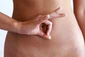 Eine Frau zeigt Ihre Hand vor dem Bauch