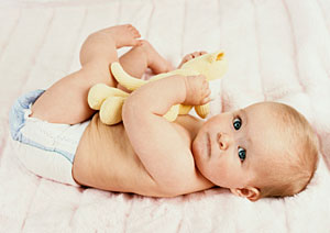 Baby mit Windel liegt auf dem R�cken und schaut in die Kamera.