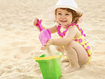 Ein kleines Kind spielt am Strand.
