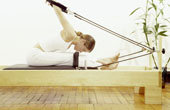 Eine Frau trainiert auf einem Pilates-Ger�t.