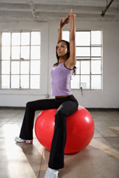 Eine Frau macht Pilates mit einem Gymnastikball
