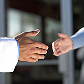 Das Bild zeigt die Hand einer Person, welche einer anderen Person die Hand reicht.