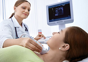 Eine �rztin untersucht die Schilddr�se einer Patientin mit Ultraschall.