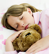Junges M�dchen schl�ft mit Teddyb�r im Arm.