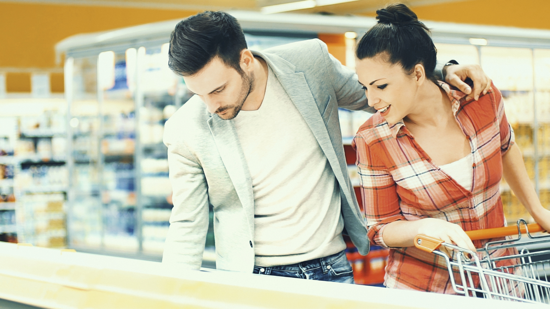 Man sieht eine Frau vor einer K�hltruhe im Supermarkt.