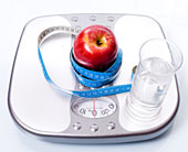 Waage mit Apfel, Glas Wasser und Ma�band
