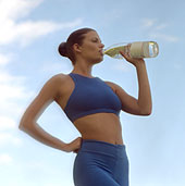 Frau trinkt Wasser aus einer Flasche