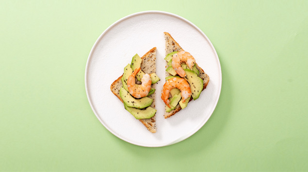 Toastbrot auf Teller mit Avocado und Shrimps