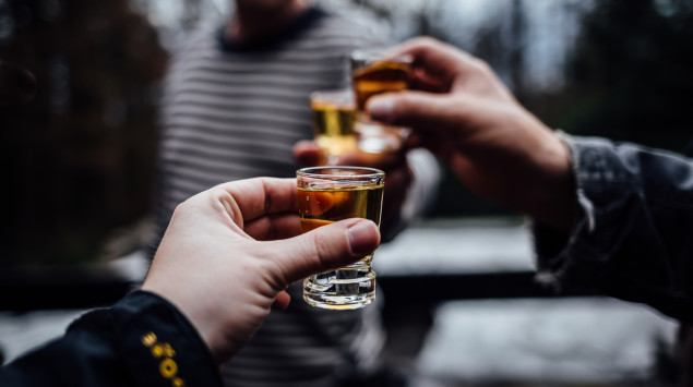 Eine Gruppe von Leuten stößt mit Shots an.