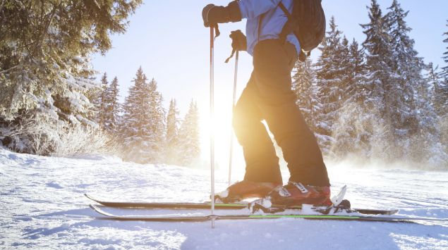 Man sieht einen Mann mit Rucksack auf Alpinski.