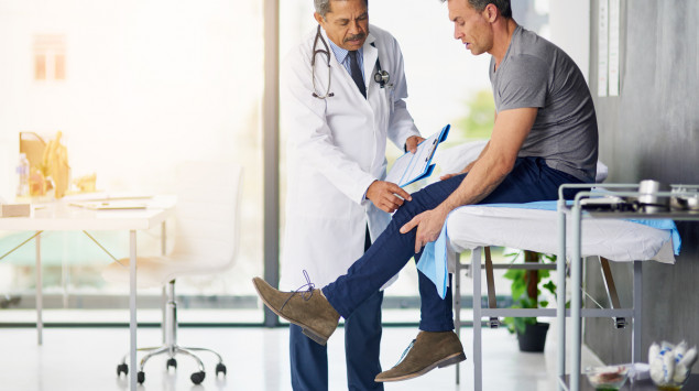 Verdacht auf Restless-Legs-Syndrom: Ein Arzt untersucht das Bein eines Patienten.