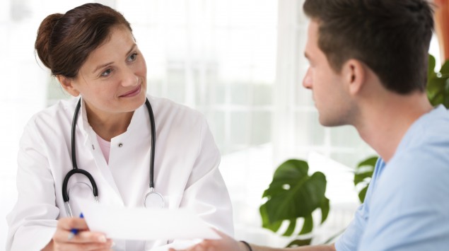 Man sieht eine Ärztin im Gespräch mit einem Patienten.