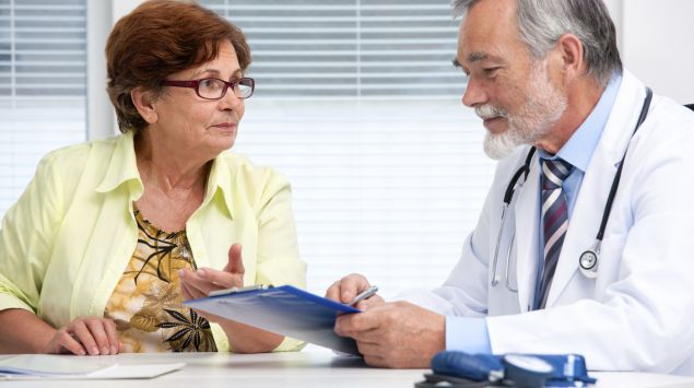 Das Bild zeigt eine Patientin, die sich mti einem Arzt unterhält.