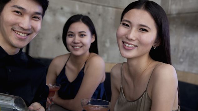 Drei Asiaten trinken Alkohol.