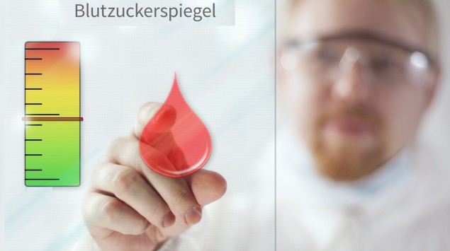 Ein Arzt deutet auf eine Grafik mit einem stilisierten Blutstropfen und einer Skala.
