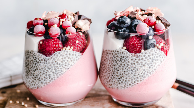 Zwei Gläser mit Chiapudding und Beeren.