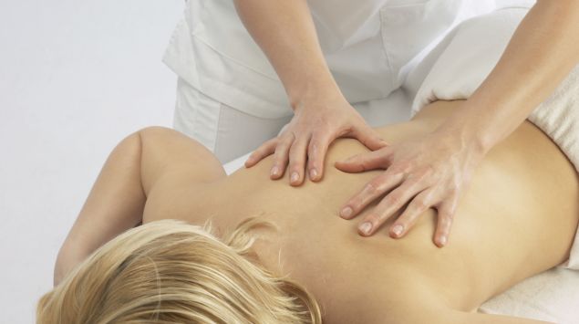 Das Bild zeigt eine Frau bei einer Rückenmassage.