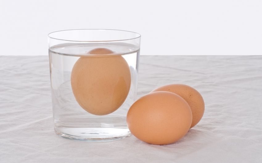 Ostereier: Man sieht ein Ei im Wasserglas und zwei Eier, die daneben liegen.